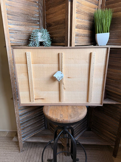 Back view of framed artwork with light canvas backing and hanging hardware