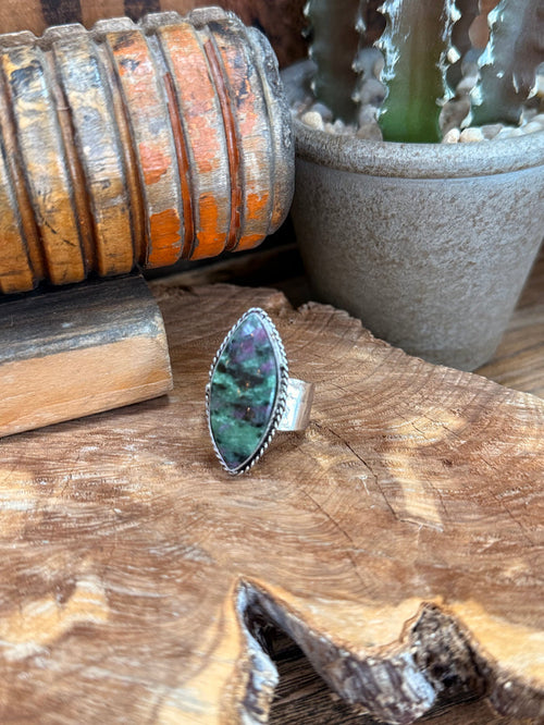 Oval green-purple gemstone ring with silver-tone prong setting, textured border