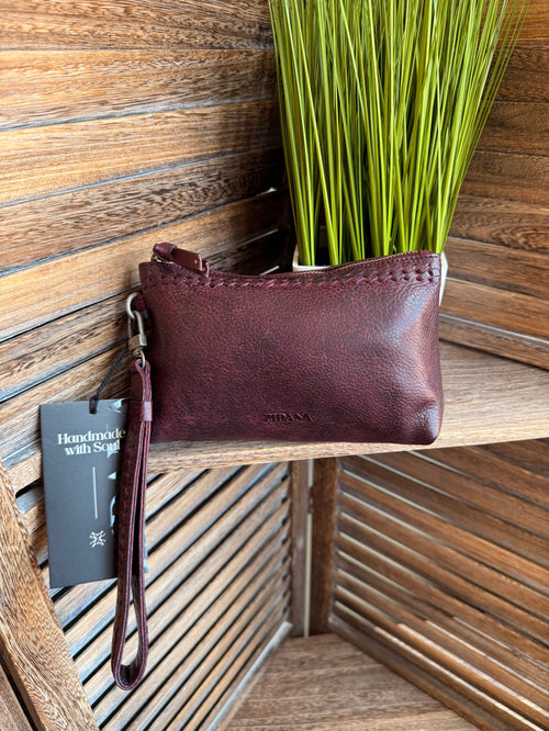 Mini wristlet bag in plum textured leather with wrist strap and zip closure