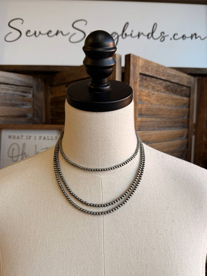 Triple layer stack chain necklace on mannequin, silver-toned links, front view