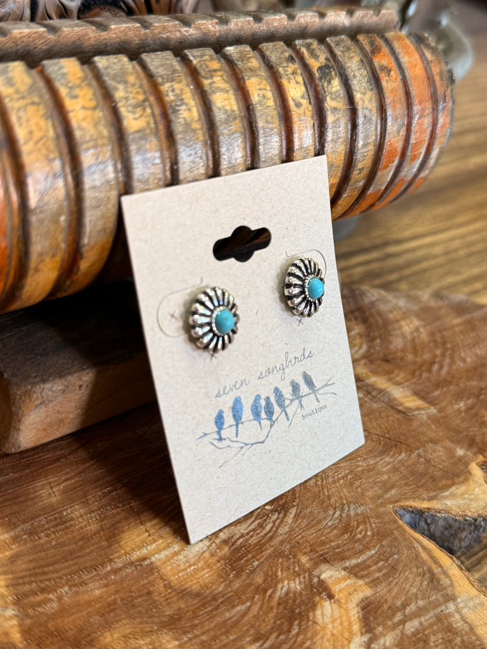 Turquoise daisy stud earrings in silver-tone round settings, shown on retail card