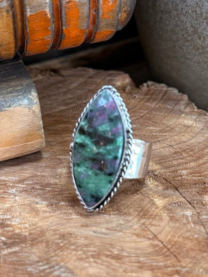 Large oval green gemstone ring with silver-tone band and raised side setting
