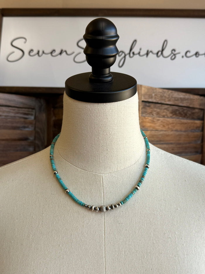Blue turquoise heishi bead necklace on a mannequin with silver spacer beads
