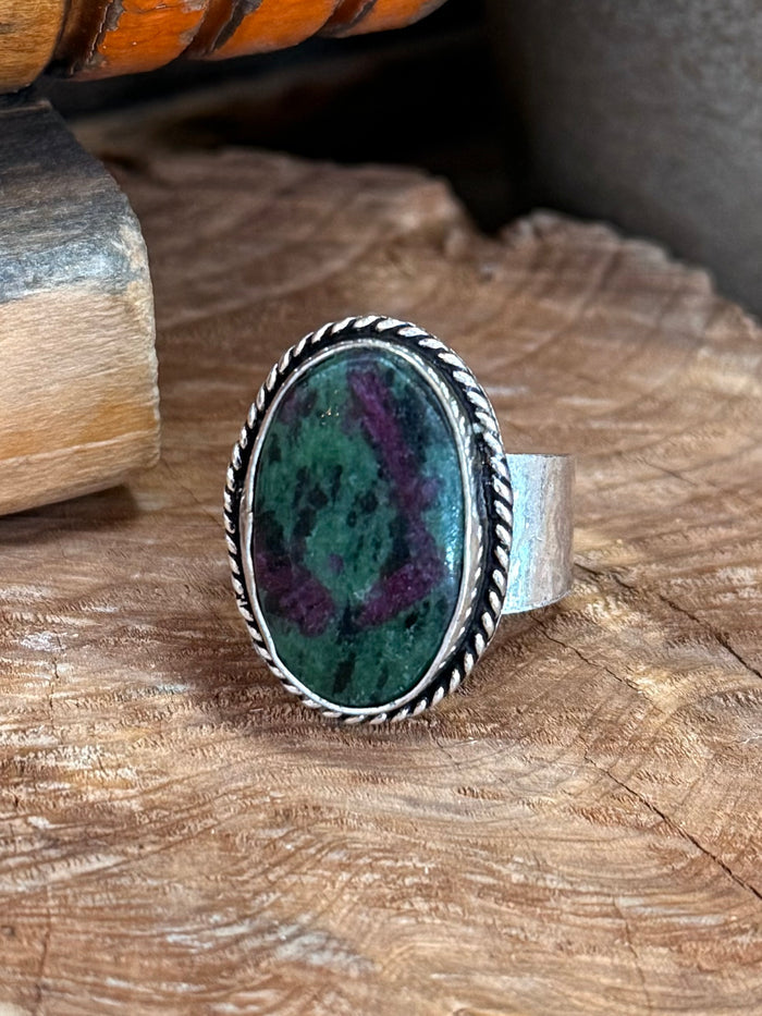 Silver-tone oval adjustable ring with green marbled stone, raised bezel and rope edge