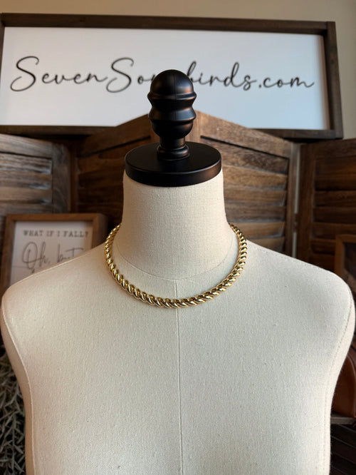 Chunky gold chain necklace on a mannequin, flat curb links, even drape