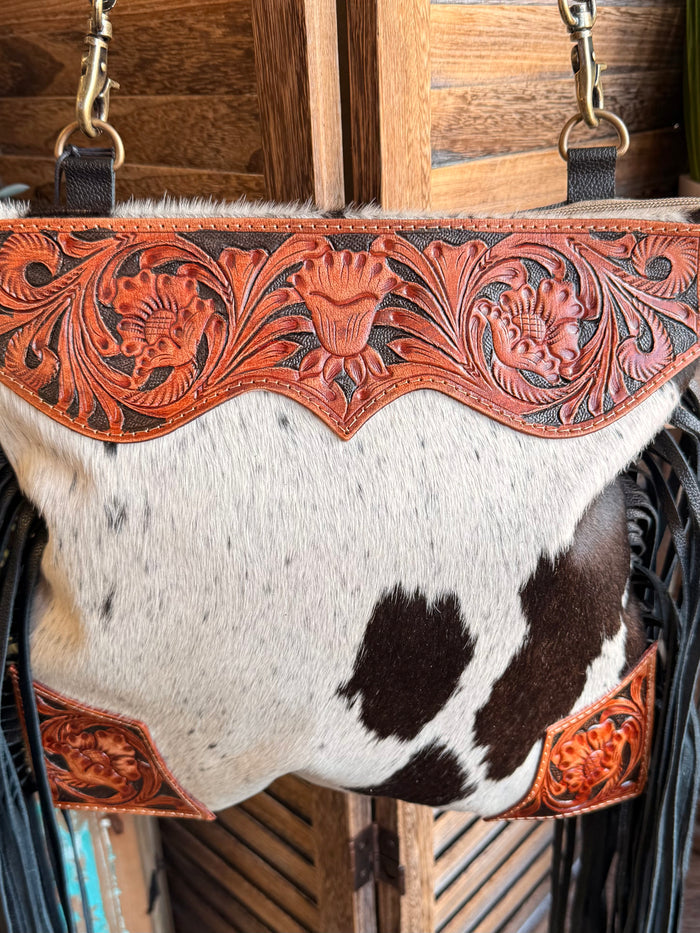 Cowhide purse front with brown-and-white patches and carved orange leather border