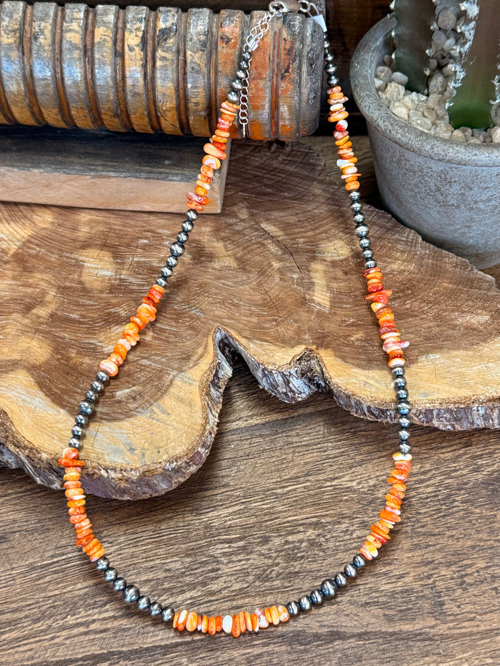 Orange spiny oyster chip bead necklace, silver-tone beaded strands on wood