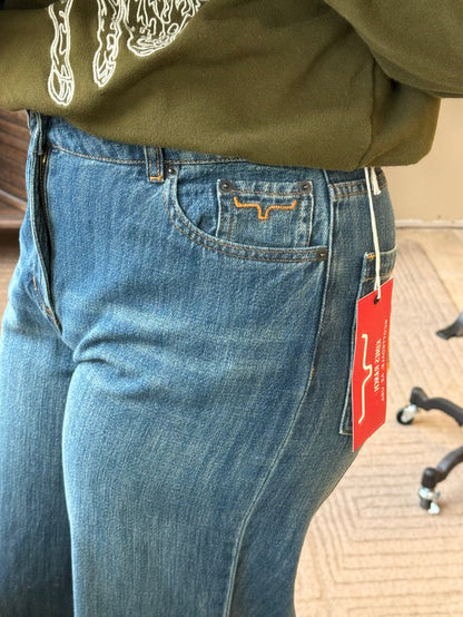 Maggie jeans close-up: blue denim with tan stitched pocket and leather logo patch