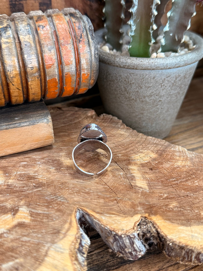 Silver-tone open-back ring with small oval gemstone centerpiece
