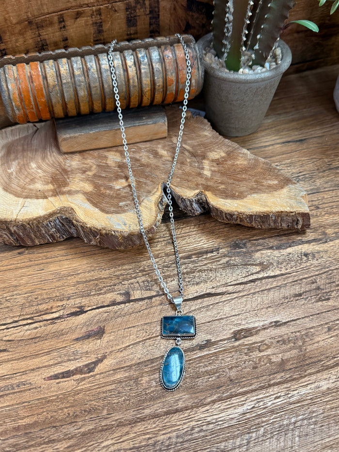 Silver-plated lariat necklace with two blue stone pendants, rectangle and oval, on chain