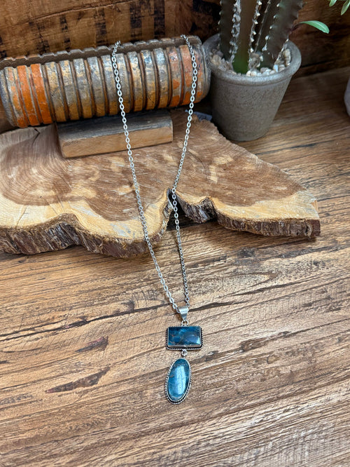 Silver-plated lariat necklace with two blue stone pendants, rectangle and oval, on chain