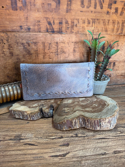 Gray cowhide checkbook wallet with pebble leather texture and stitched front edge