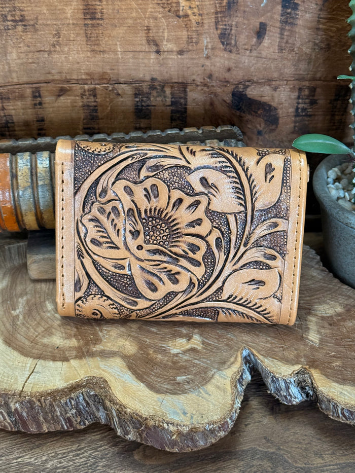 Tan trifold cowhide wallet with large floral embossing and button snap