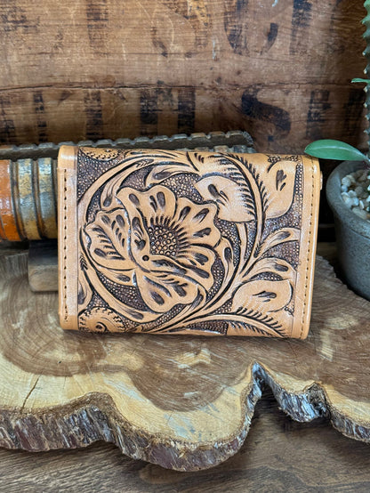 Tan trifold cowhide wallet with large floral embossing and button snap
