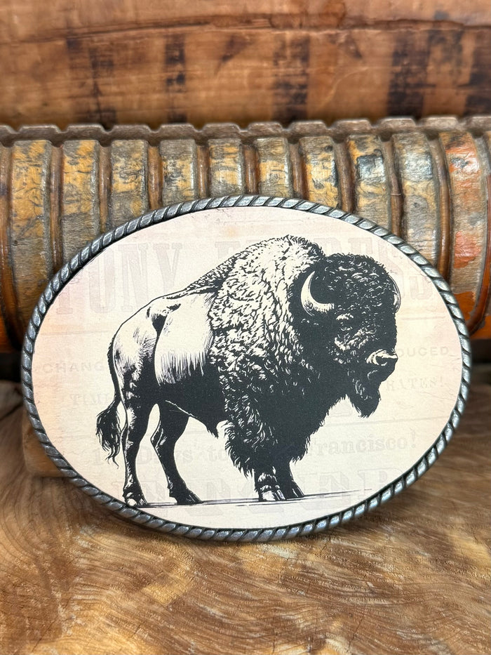 Close-up oval buffalo belt buckle with black bison graphic on white face and dark rim