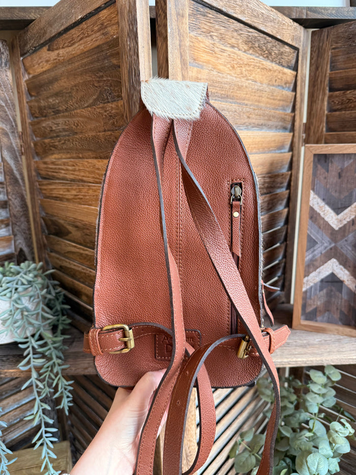 Hair-on cowhide drawstring backpack with brown leather back and side straps