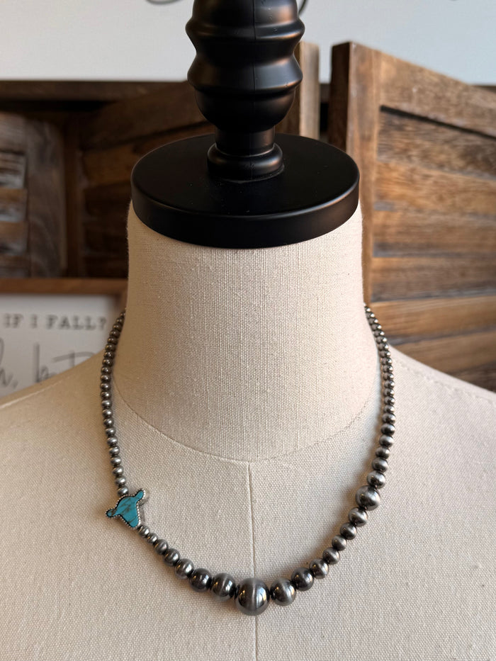 Silver-tone beaded necklace with turquoise cowhead pendant on bust