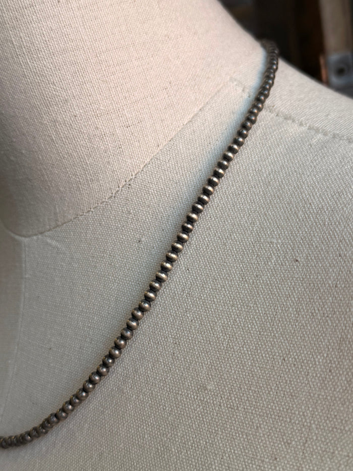 Sterling silver beaded necklace chain with small round beads along the curve