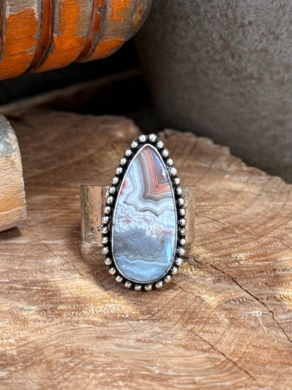 Teardrop stone ring in blue-gray with ornate silver beaded border