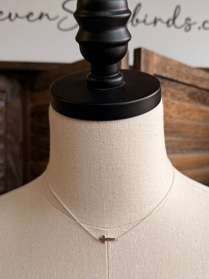 Silver cross pendant necklace with a small cross charm on a fine chain