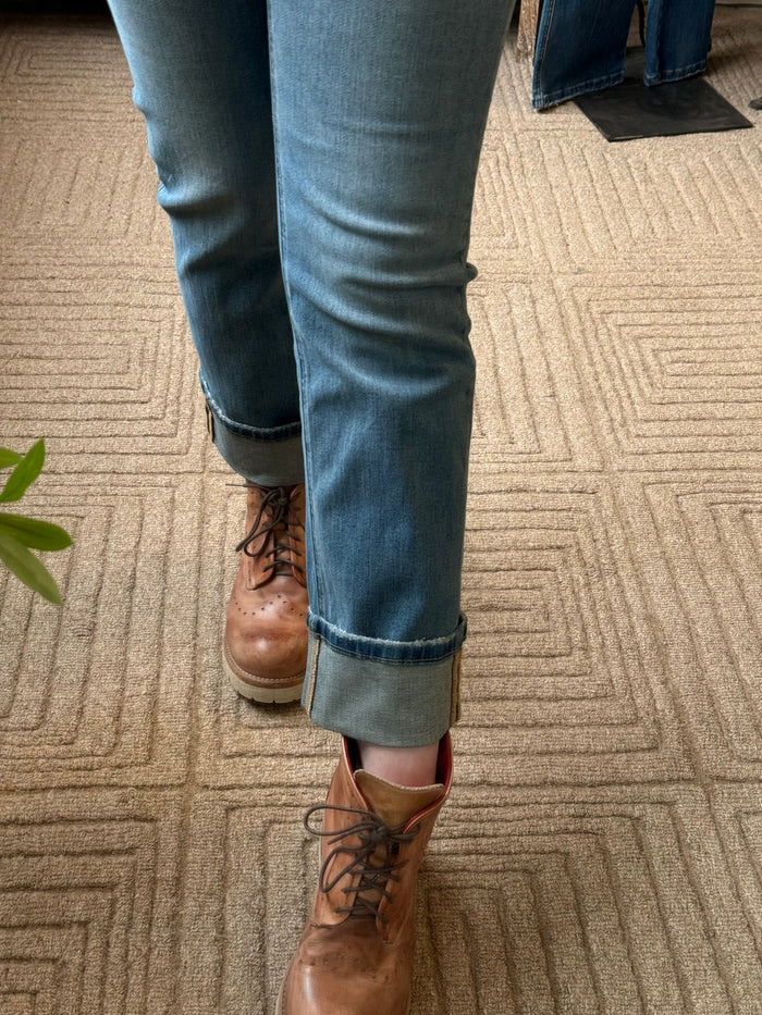 Light blue jeans with cuffed hem and subtle whisker wash on the thigh