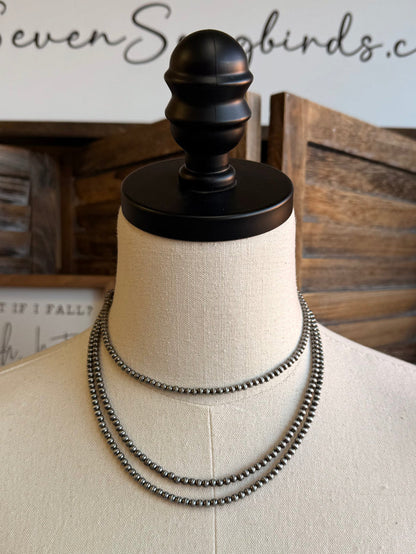 Triple layer stack chain necklace on mannequin, silver-toned, slightly wider angle