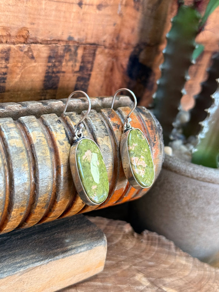 Silver-plated fishhook earrings with green oval natural stone cabochons, side view of hooks