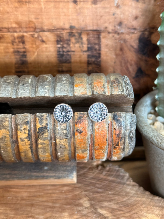 Silver concho stud earrings with round embossed floral center detailing
