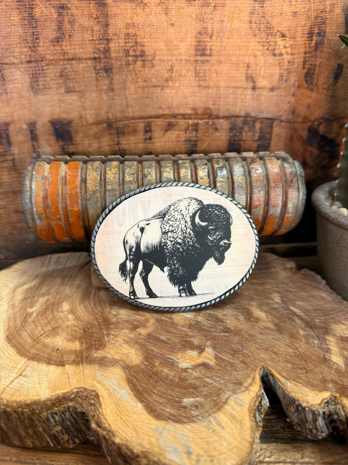 Oval buffalo belt buckle with black-and-white bison illustration and dark stitched border