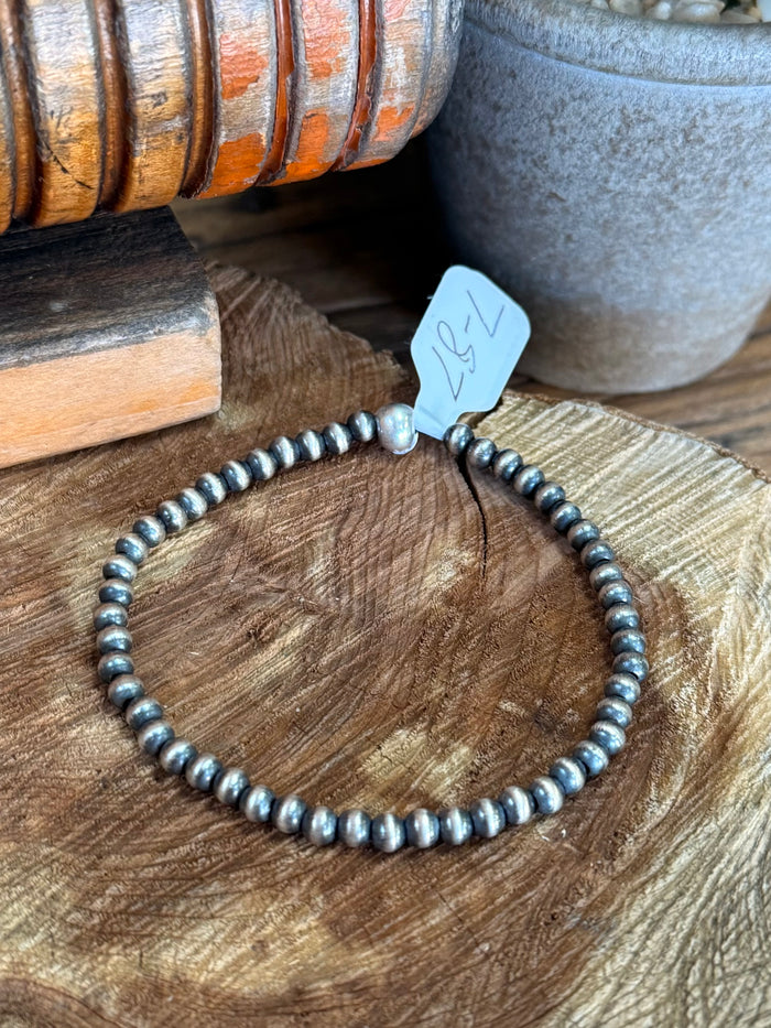 Sterling silver beaded stretchy bracelet with stamped blue tag at top