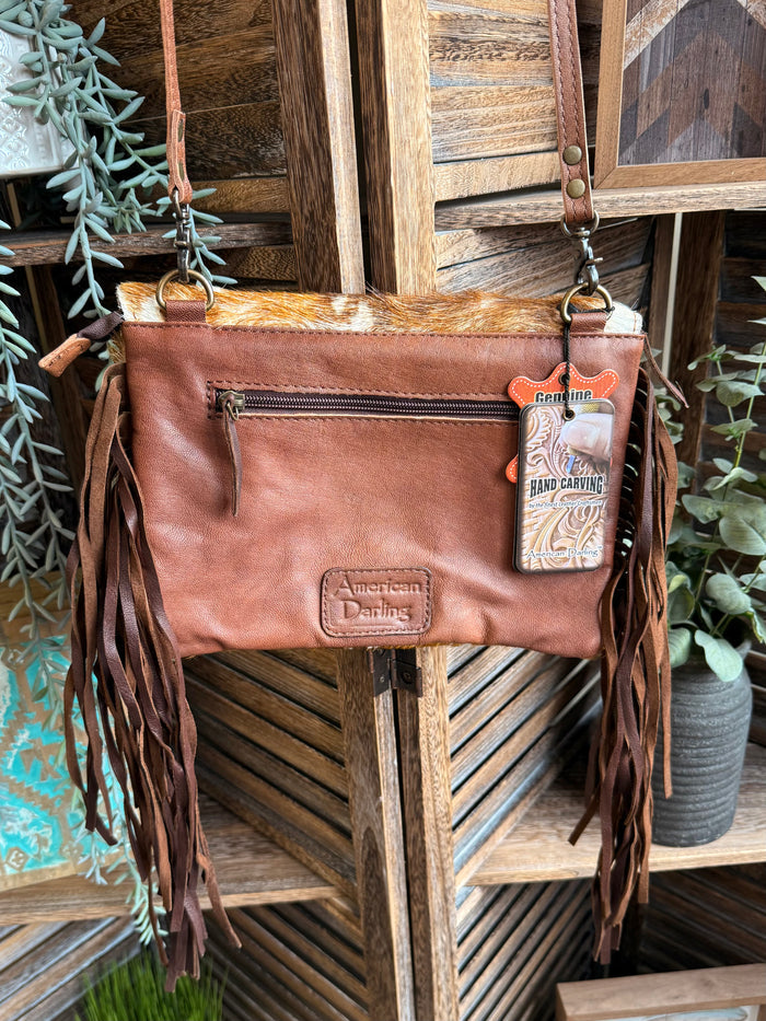 Brown leather crossbody clutch with fringe, top zip, and western logo patches