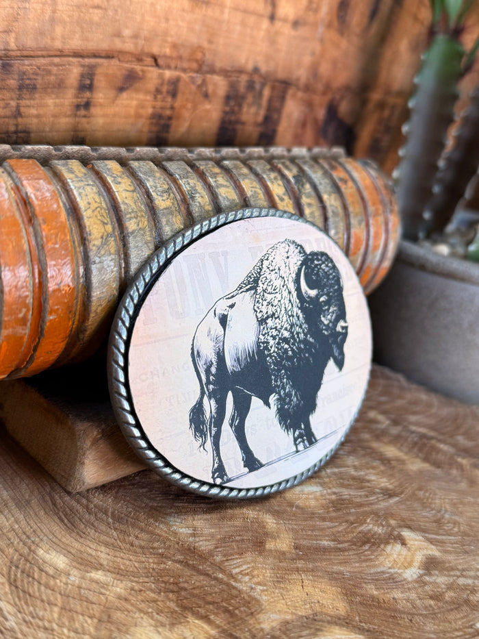 Angled oval buffalo belt buckle with black-and-white bison graphic on white background