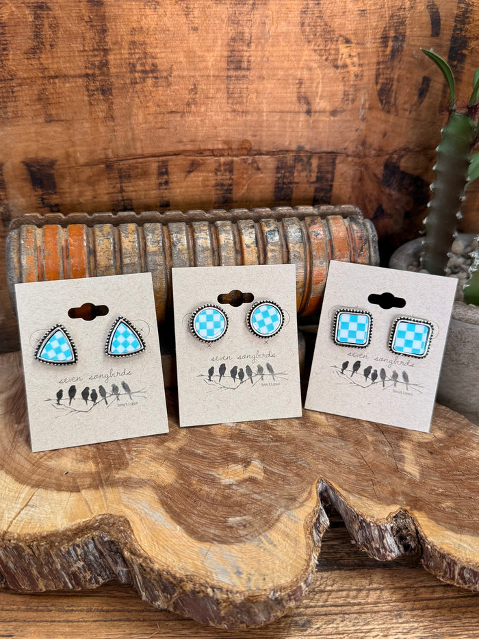 Three pairs of blue-and-white checkered stud earrings on display cards