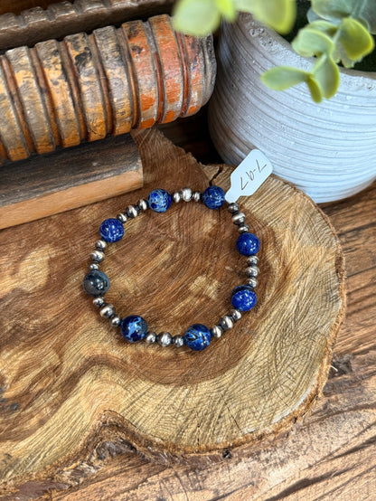 Stretchy beaded bracelet featuring blue jasper spheres with silver pearl and metal beads