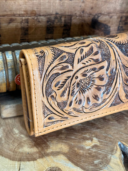 Tan cowhide wallet front with carved floral embossing and contrast stitching