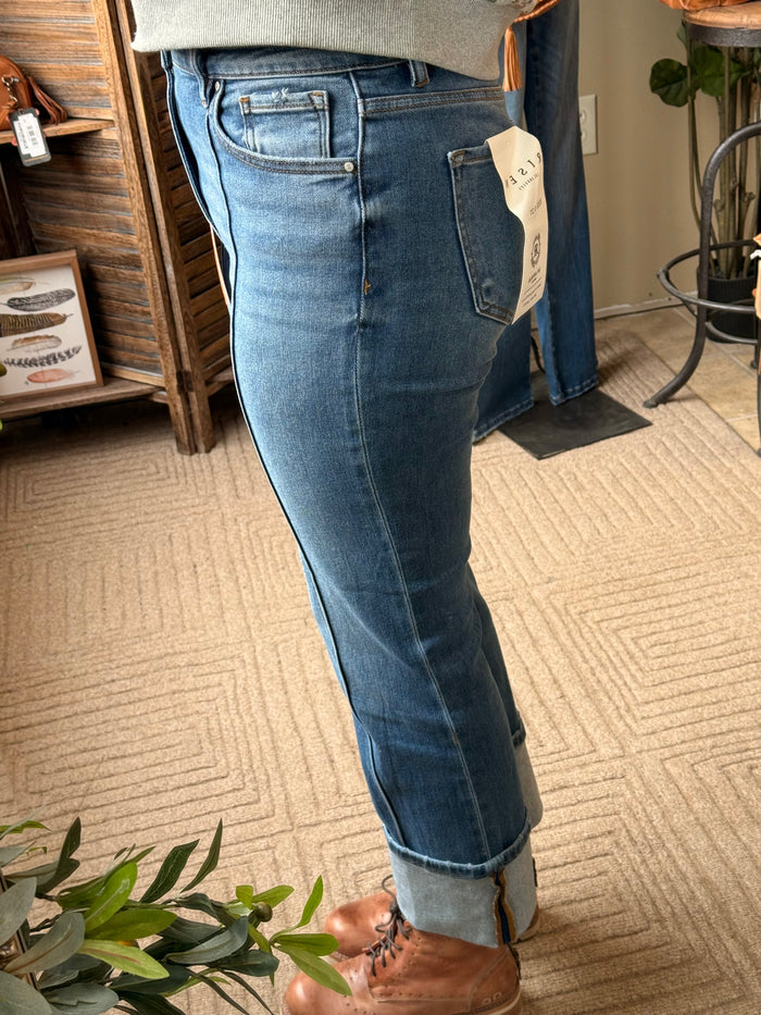 Medium-wash cuffed jeans with front seam, belt loops, and back tag label.