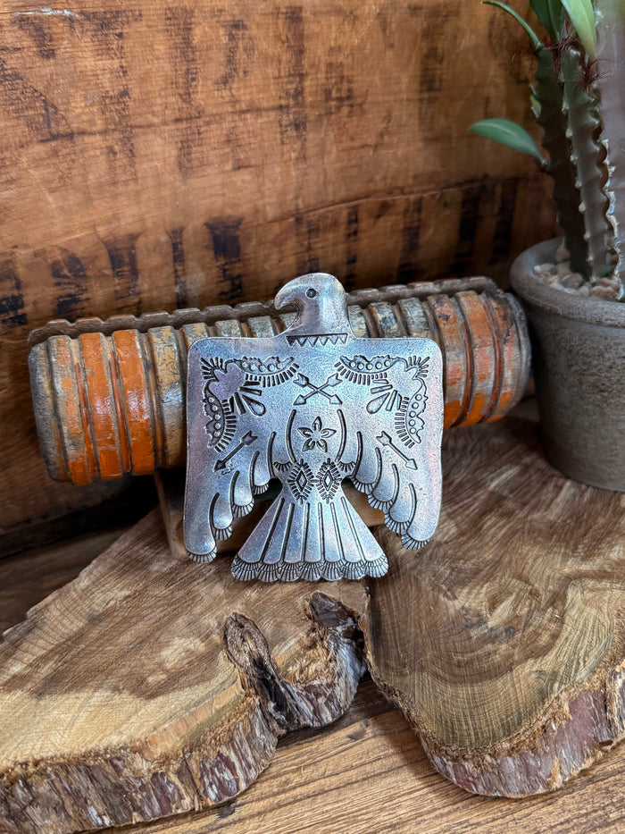 Silver-tone belt buckle with engraved thunderbird wings and central shield