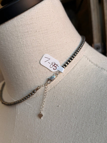 Sterling silver necklace with clasp tag and small dangling charm below