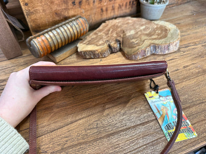 Burgundy leather crossbody wallet with top flap and hanging tag charm