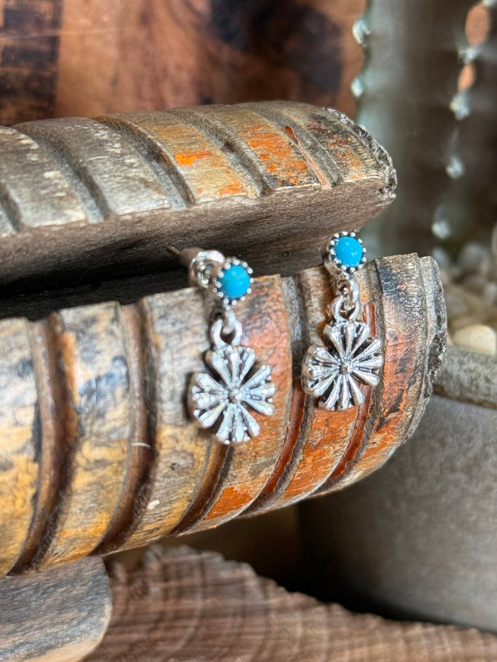 Turquoise and silver-tone dangle earrings with round cabochon and starburst flower