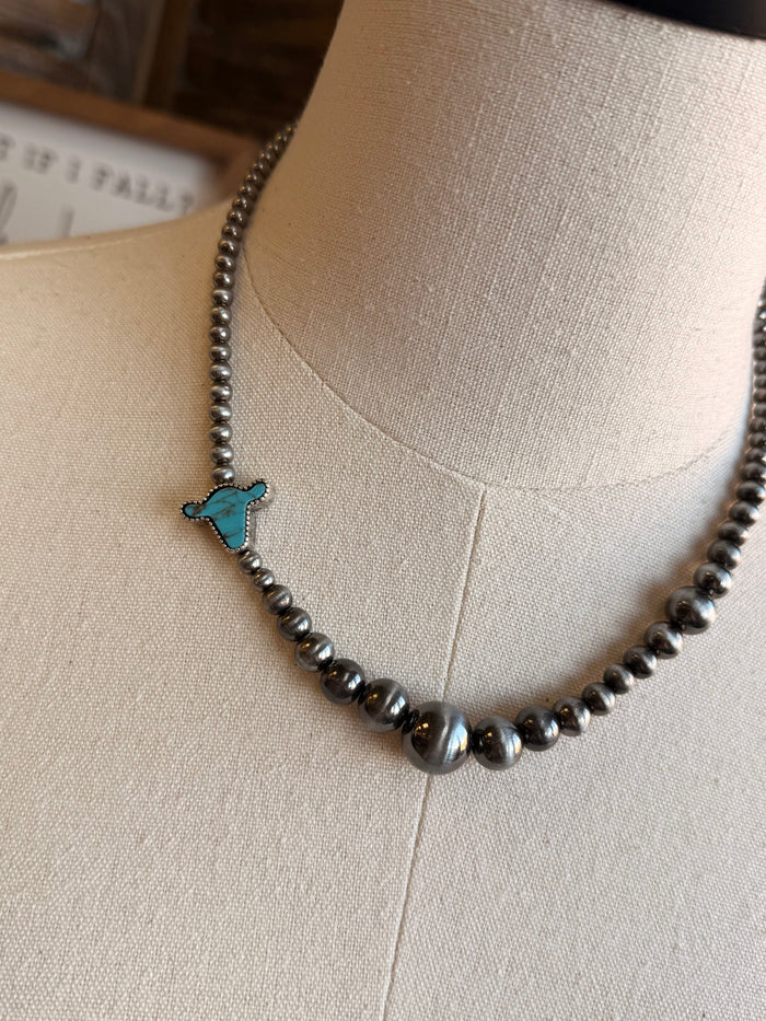Silver-tone beaded necklace with turquoise cowhead charm close-up