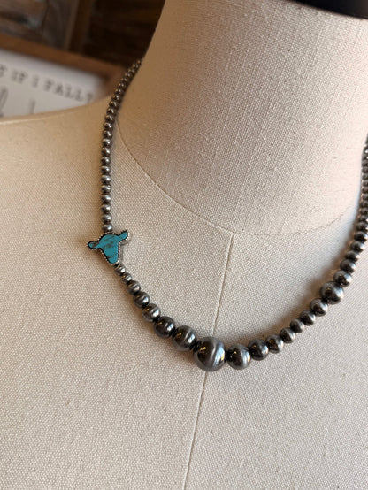 Silver-tone beaded necklace with turquoise cowhead charm close-up