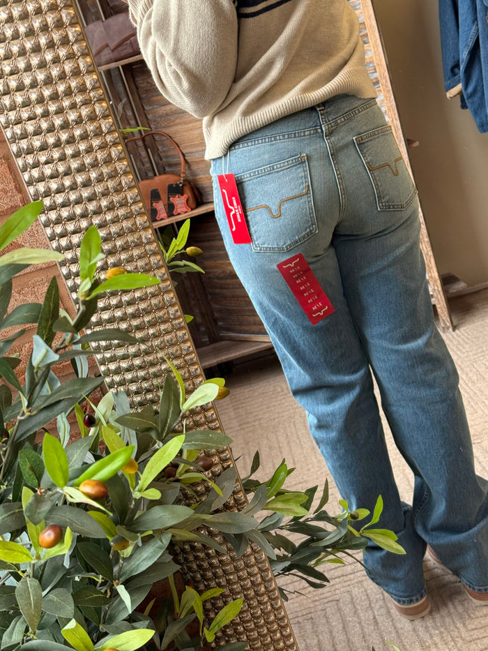 Mid-wash blue jeans with back yoke, two rear pockets, and stitched logo detail.