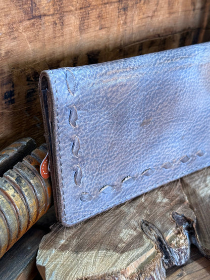 Gray cowhide checkbook wallet side view, embossed pebble grain and decorative stitching