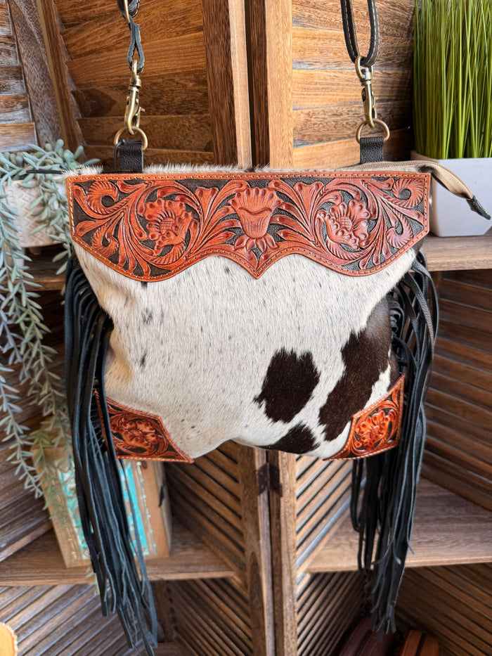 Cowhide purse with carved orange leather flap and long black fringe, crossbody straps