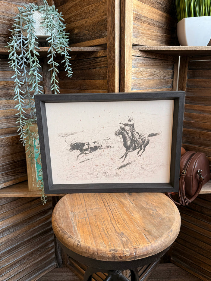 Framed cowboy roping longhorn print with dark gray frame and detailed line art
