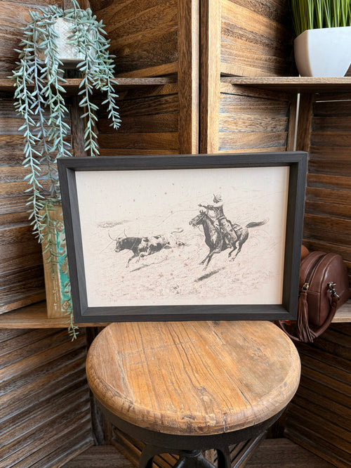 Framed cowboy roping longhorn print with dark gray frame and detailed line art