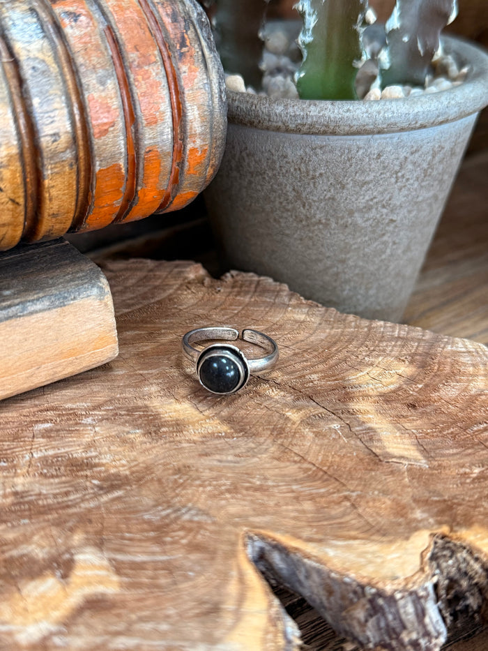 Adjustable silver-toned ring with round dark stone cabochon in bezel setting