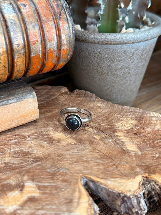 Adjustable silver-toned ring with round dark stone cabochon in bezel setting
