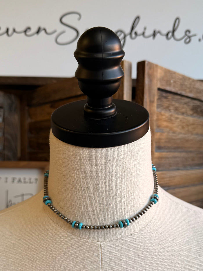 Turquoise and silver bead necklace on display on mannequin